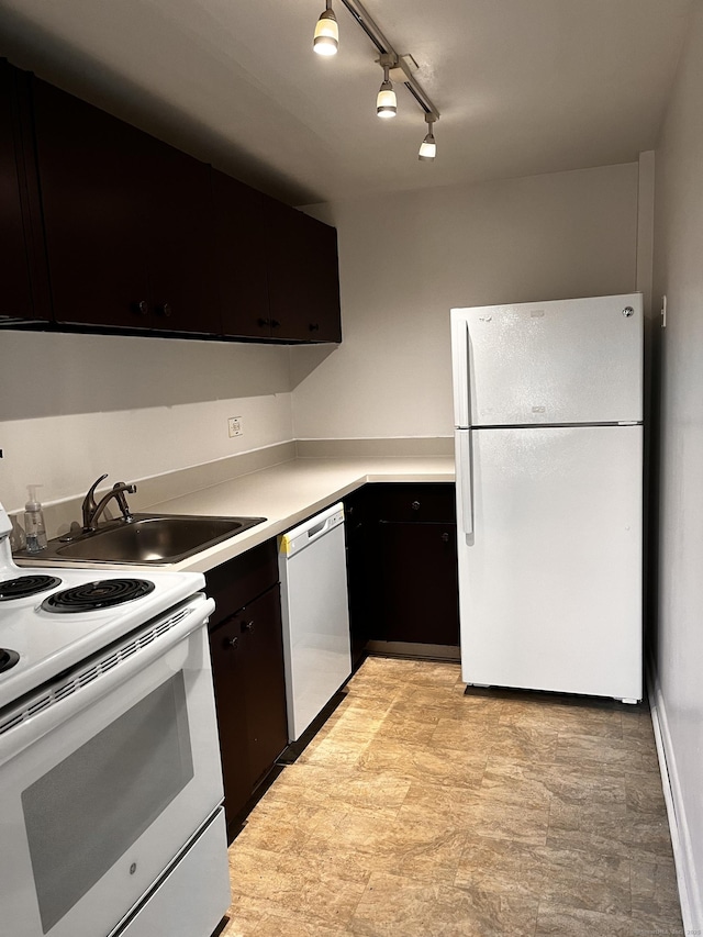 kitchen with dark brown cabinets, track lighting, white appliances, and sink