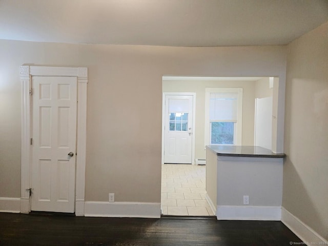 unfurnished room with wood-type flooring and a baseboard radiator