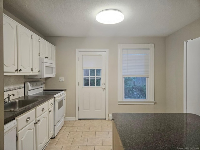 kitchen with white appliances, white cabinets, sink, decorative backsplash, and a textured ceiling