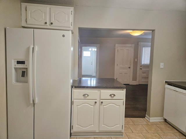 kitchen featuring white cabinetry, light tile patterned floors, and white appliances