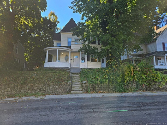 victorian house with covered porch and a balcony