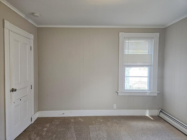 spare room featuring carpet floors, ornamental molding, and a baseboard heating unit