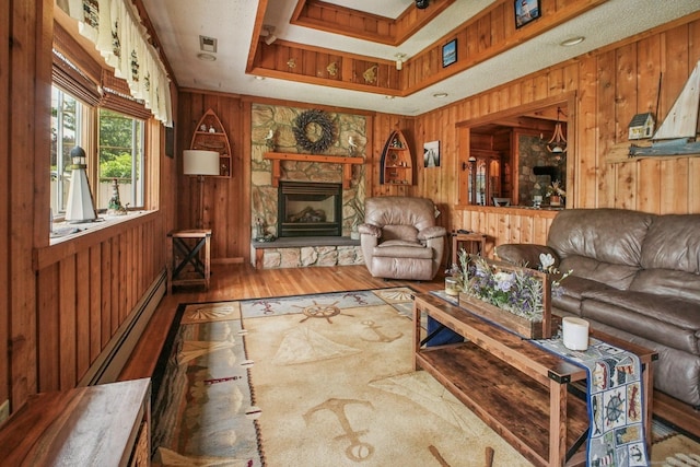 72 Providence Ave, Shelton, CT 06484 - living area with a baseboard heating unit, wood walls, wood finished floors, and a stone fireplace