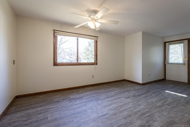 empty room featuring ceiling fan, dark hardwood / wood-style flooring, and a textured ceiling