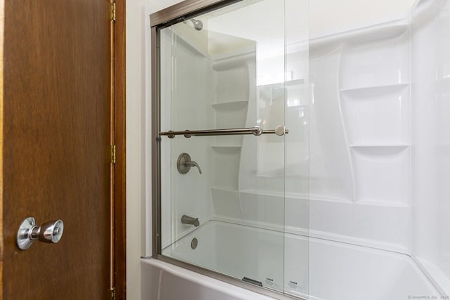 bathroom featuring combined bath / shower with glass door