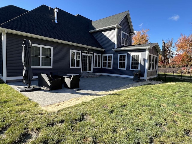 rear view of house featuring a lawn and a patio