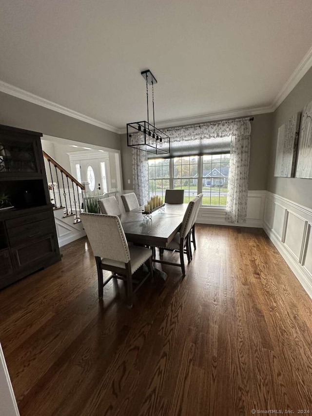 dining area featuring a notable chandelier, crown molding, and dark wood-type flooring