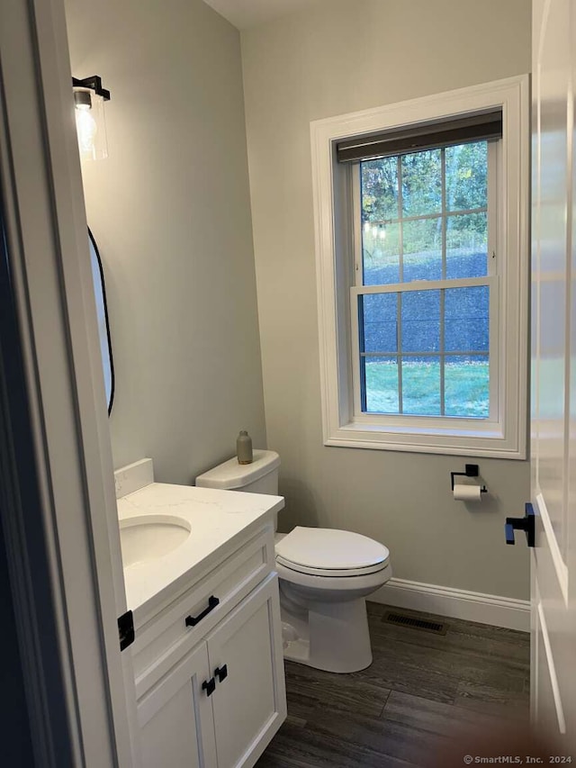 bathroom featuring toilet, vanity, and hardwood / wood-style flooring