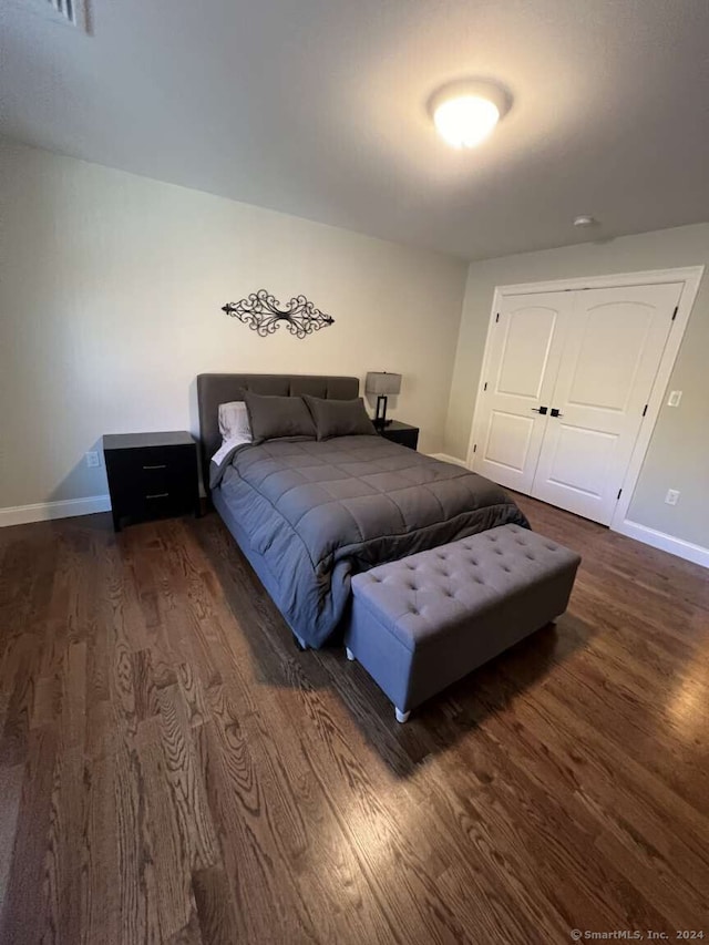 bedroom with a closet and dark hardwood / wood-style flooring