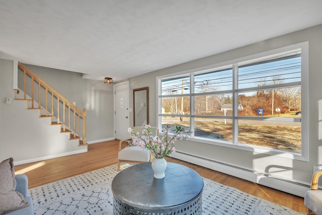 living room with light hardwood / wood-style floors and a baseboard heating unit