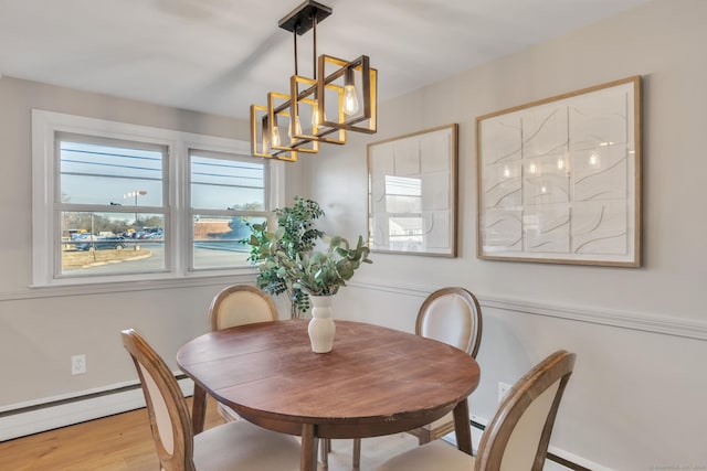 dining space featuring baseboard heating and light hardwood / wood-style flooring