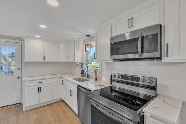 kitchen with pendant lighting, sink, white cabinetry, and stainless steel appliances