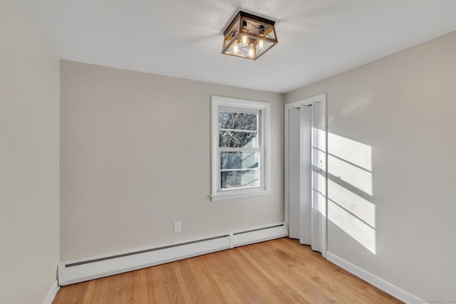 spare room featuring light wood-type flooring and baseboard heating