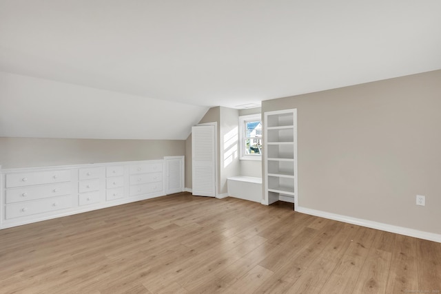 additional living space with lofted ceiling and light hardwood / wood-style flooring