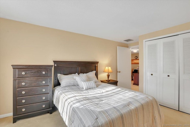 bedroom featuring light colored carpet and a closet