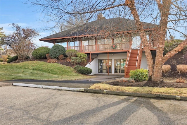 view of front of house featuring a wooden deck and a front lawn