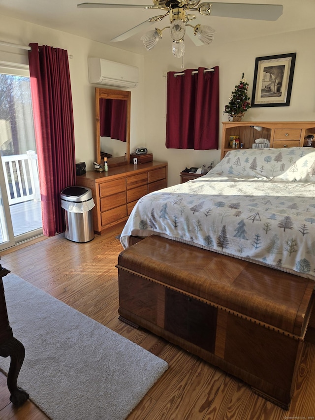 bedroom with access to outside, a wall mounted AC, ceiling fan, and hardwood / wood-style flooring