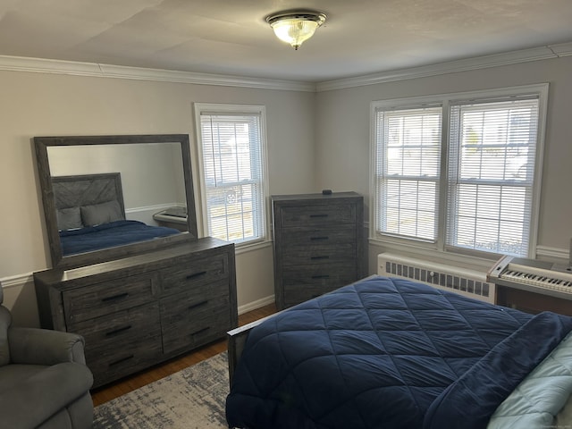 bedroom with crown molding, dark wood-type flooring, baseboards, and radiator