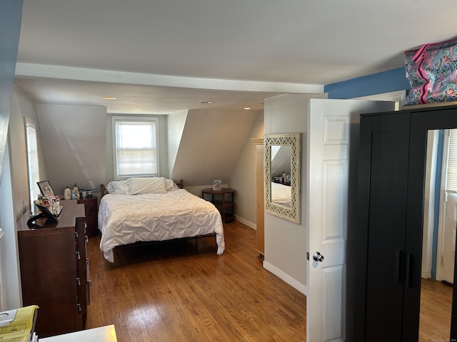 bedroom featuring vaulted ceiling, wood finished floors, and baseboards