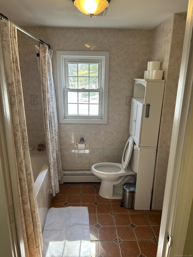 full bathroom with a baseboard radiator, tile patterned flooring, toilet, tile walls, and tiled shower / bath