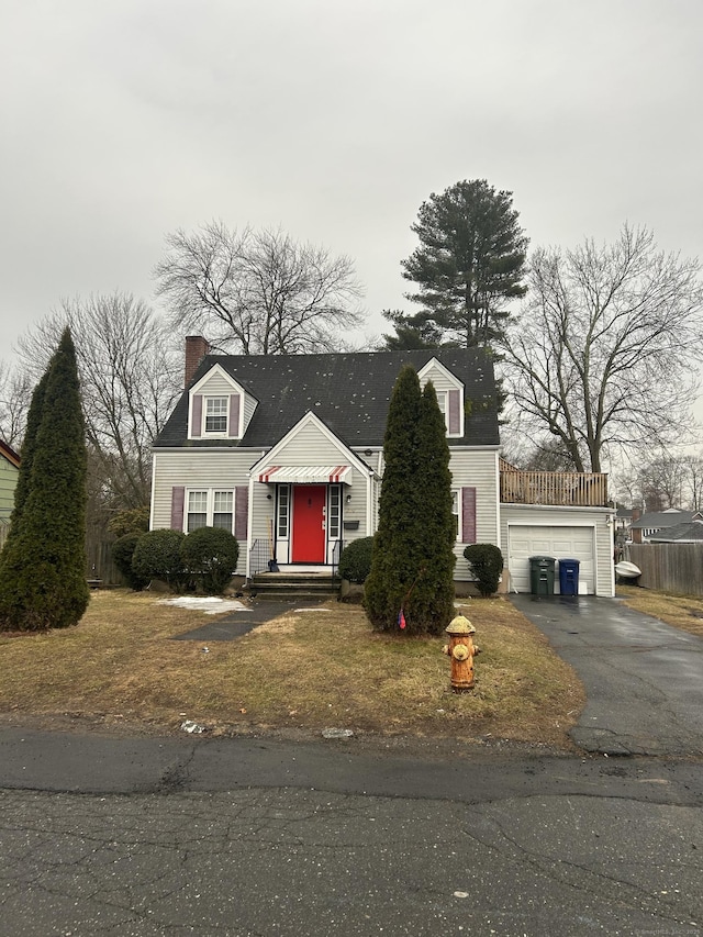 new england style home with aphalt driveway and a chimney