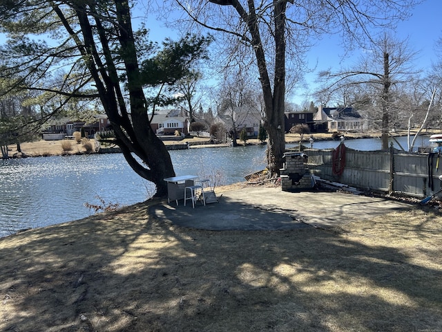 view of yard with a water view and fence