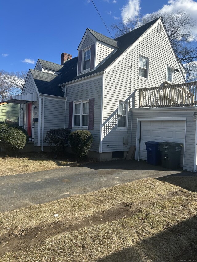 view of property exterior with a garage and a chimney