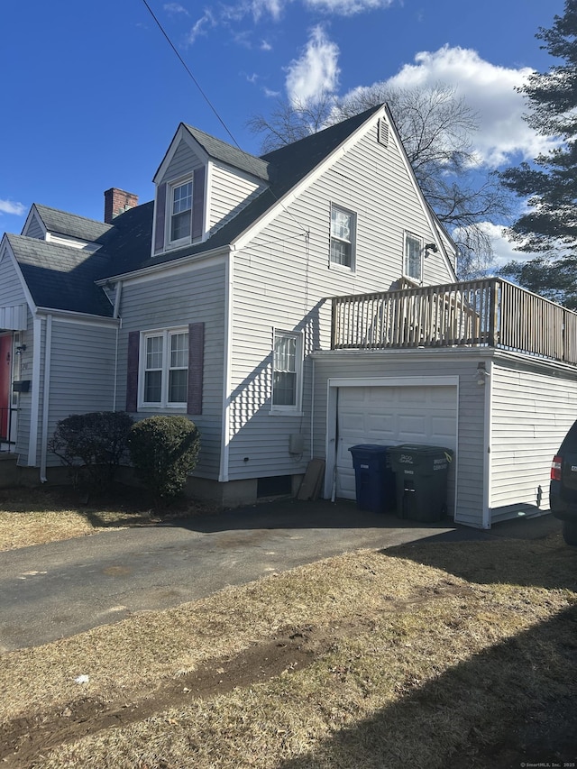 view of property exterior featuring aphalt driveway and a chimney