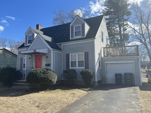 cape cod house with a garage and aphalt driveway