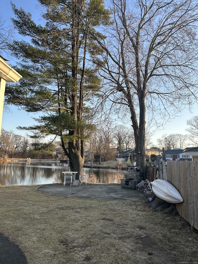 view of yard featuring fence and a water view