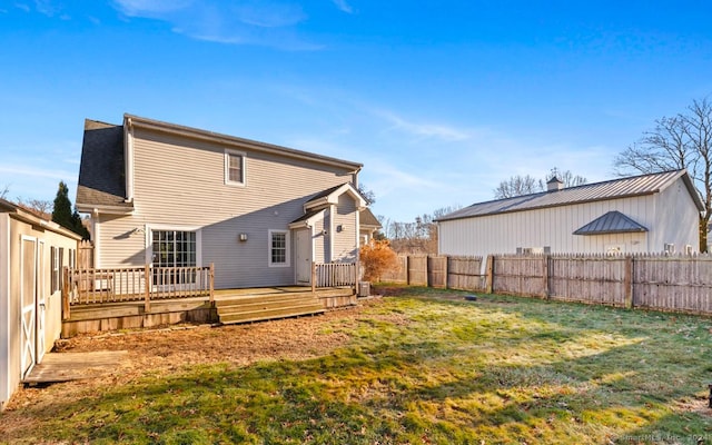 back of house featuring a deck and a yard