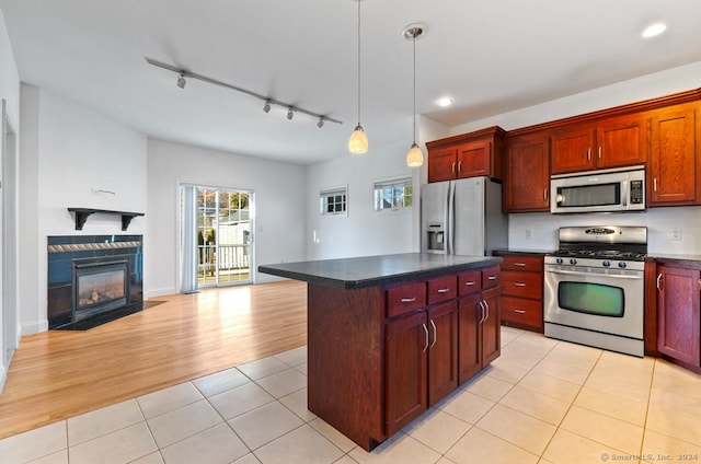 kitchen with track lighting, stainless steel appliances, light hardwood / wood-style flooring, a center island, and hanging light fixtures