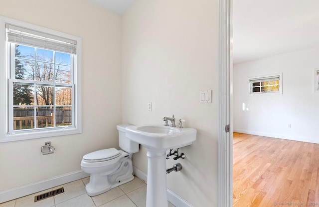 bathroom with hardwood / wood-style floors and toilet