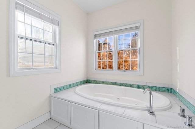 bathroom with tile patterned flooring, a healthy amount of sunlight, and a tub to relax in