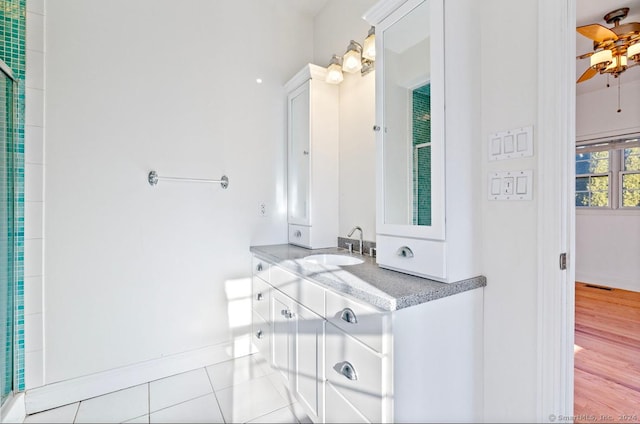 bathroom with hardwood / wood-style floors, vanity, ceiling fan, and a shower with shower door