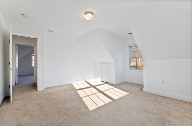 bonus room featuring light colored carpet and vaulted ceiling