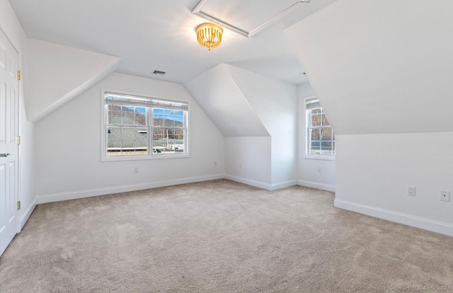 bonus room with lofted ceiling, light colored carpet, and a healthy amount of sunlight