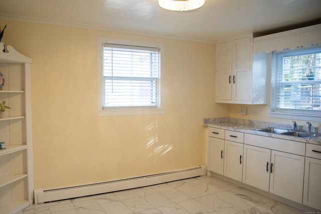 kitchen with white cabinets, crown molding, sink, and baseboard heating