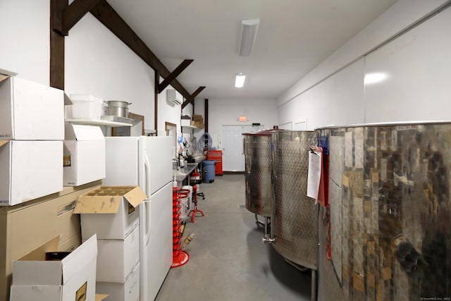 basement featuring an AC wall unit and white fridge