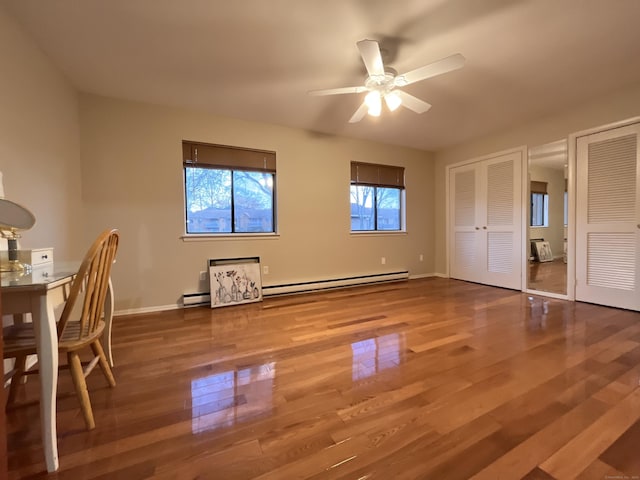 interior space featuring ceiling fan, hardwood / wood-style floors, and a baseboard heating unit