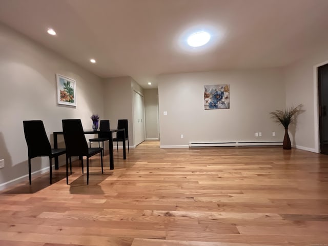 dining area featuring light wood-type flooring and a baseboard heating unit