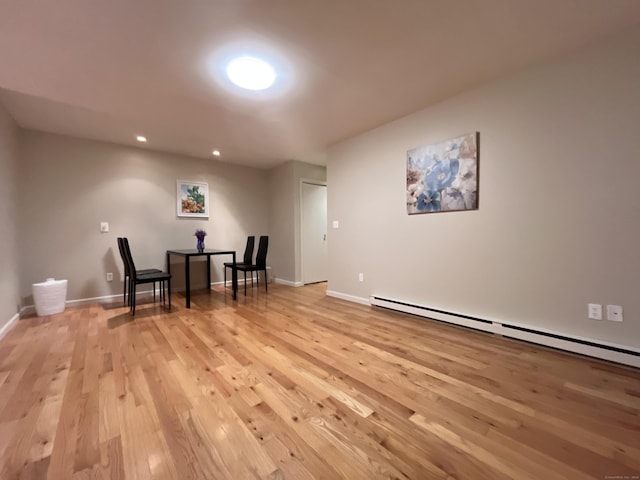 unfurnished room with a baseboard radiator and light hardwood / wood-style flooring