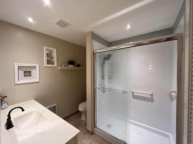 bathroom featuring tile patterned flooring, vanity, toilet, and walk in shower