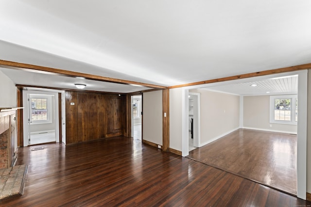 unfurnished living room with beam ceiling, dark wood-type flooring, and a fireplace