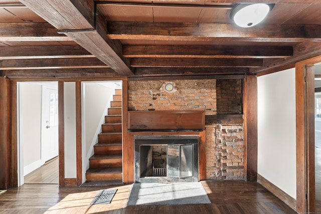 unfurnished living room with beamed ceiling and hardwood / wood-style floors