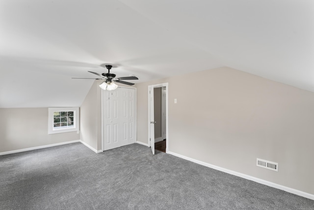 bonus room with vaulted ceiling, ceiling fan, and dark colored carpet