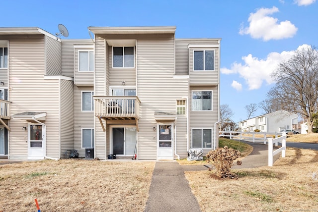 multi unit property featuring a front yard and cooling unit