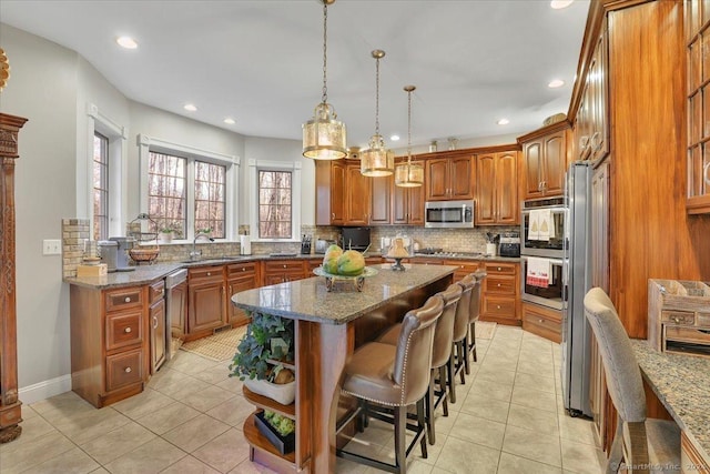 kitchen with a kitchen island, dark stone countertops, sink, and appliances with stainless steel finishes