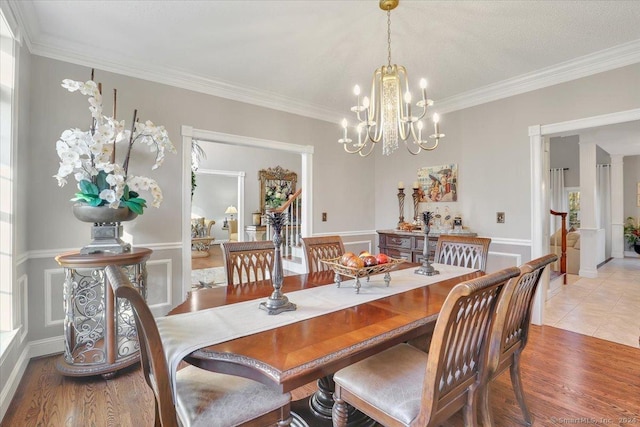 dining space with a notable chandelier, hardwood / wood-style floors, plenty of natural light, and ornamental molding