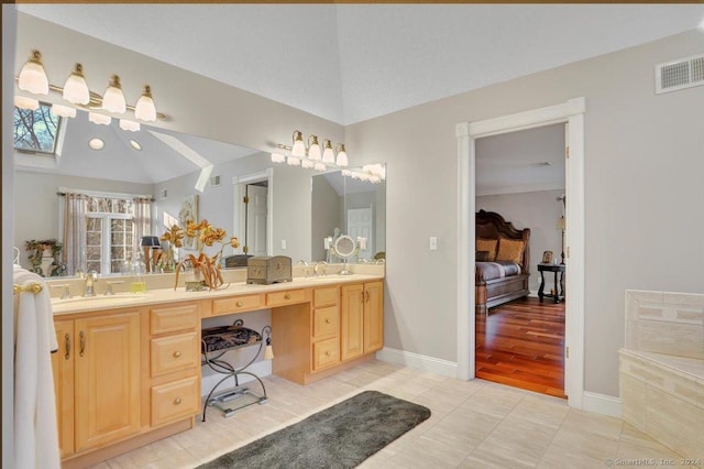 bathroom with tile patterned floors, vanity, and lofted ceiling